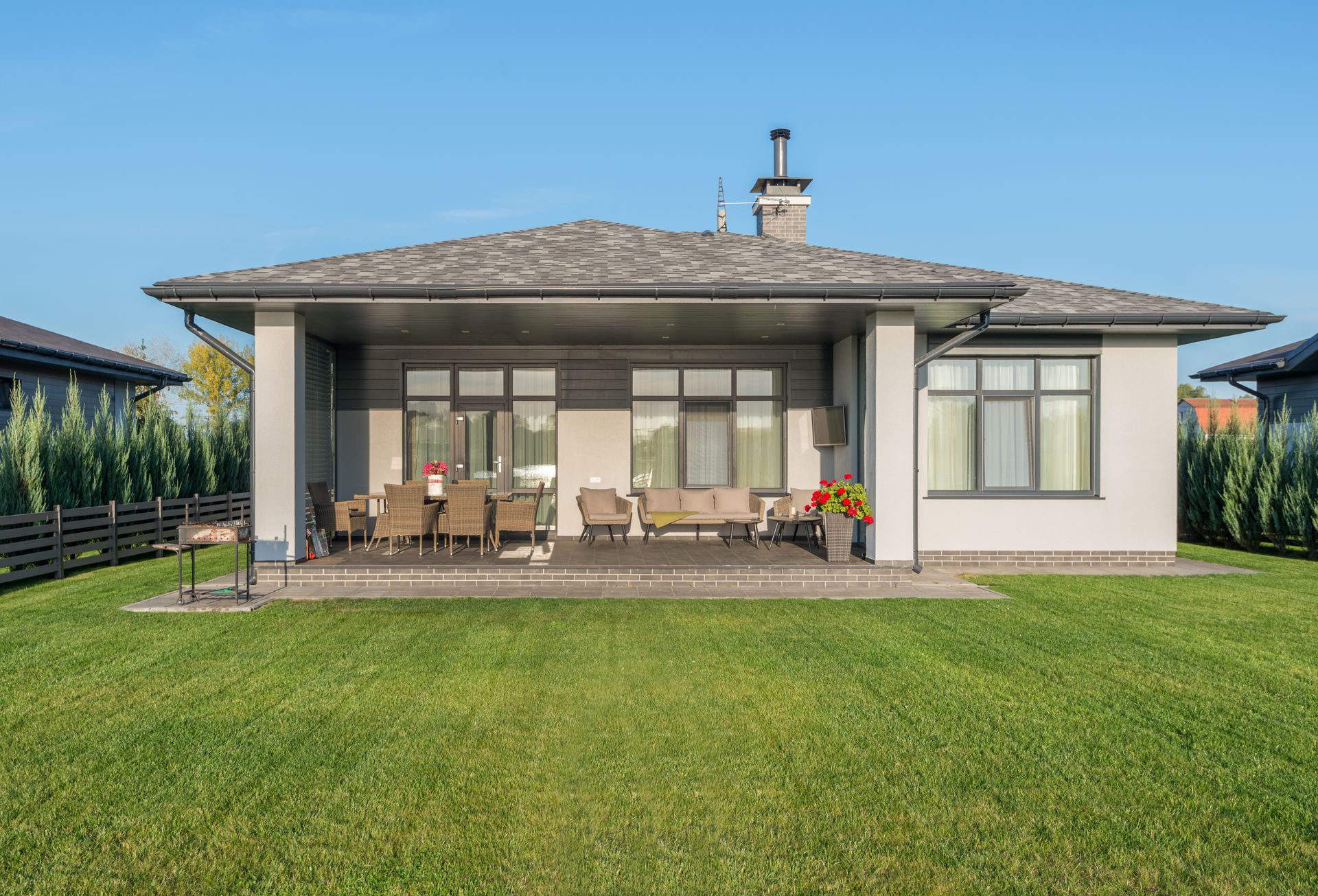 Modern house with a large manicured lawn and lush planted gardens