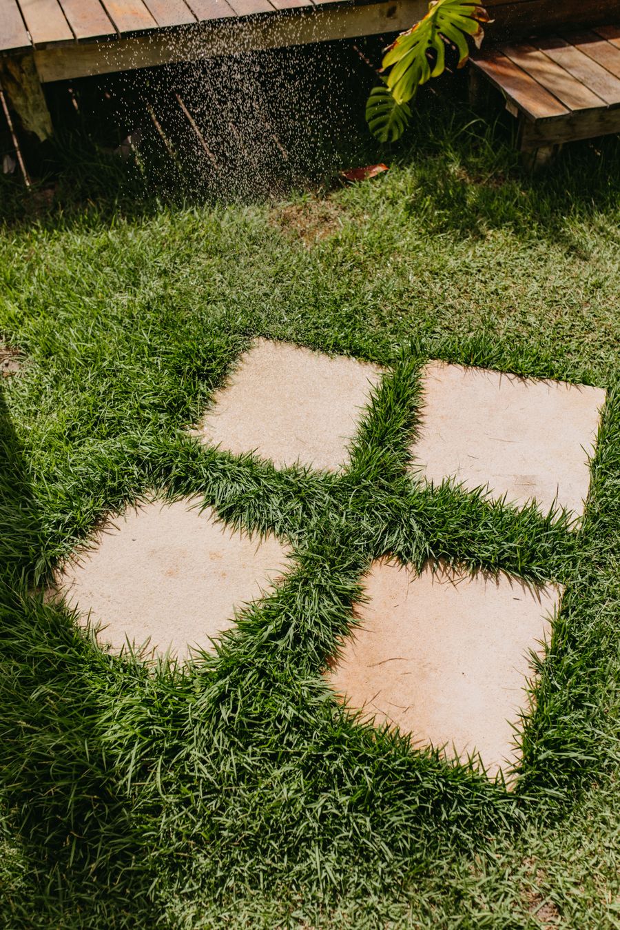 Square stone pavers set into a green lawn